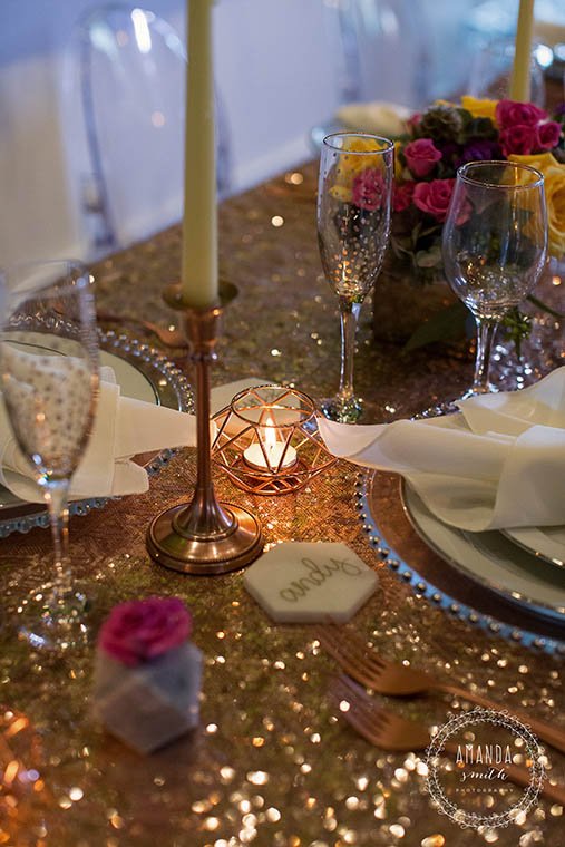 Candlelit gold table setting with flowers and glassware